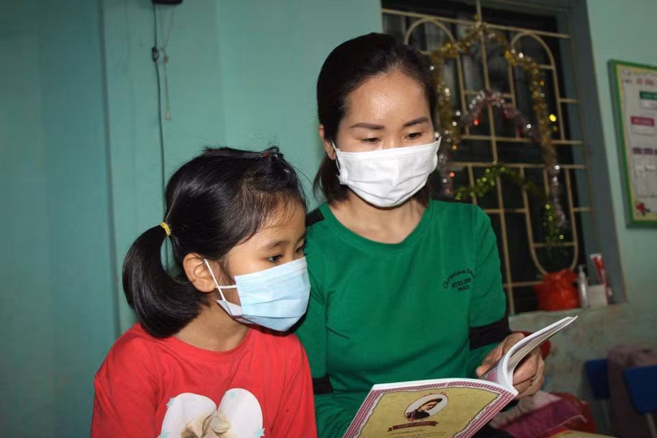 Một người mẹ vào khu cách ly cùng con. (Ảnh: PV/Vietnam+)