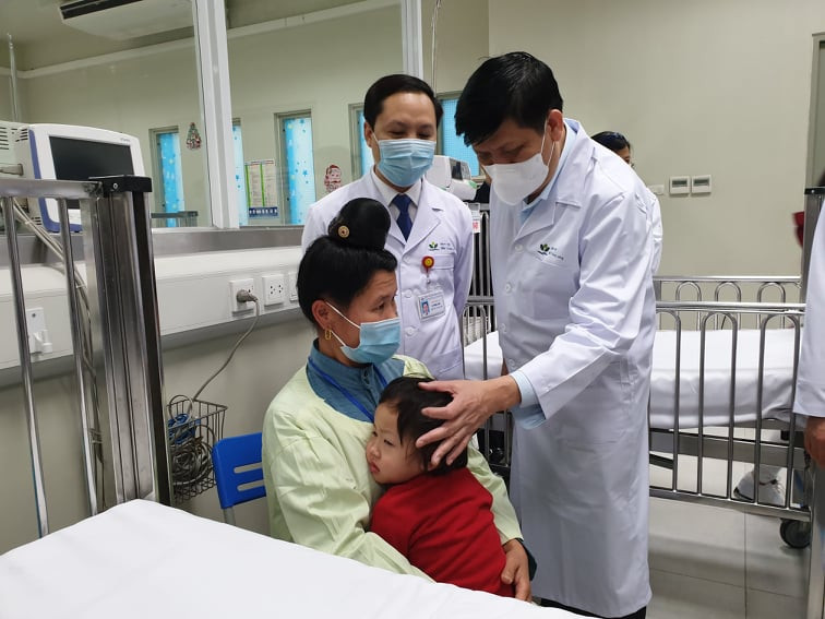 Bộ trưởng Bộ Y tế thăm hỏi một bệnh nhân ở Sơn La đang điều trị tại Bệnh viện Nhi Trung ương. (Ảnh: PV/Vietnam+)