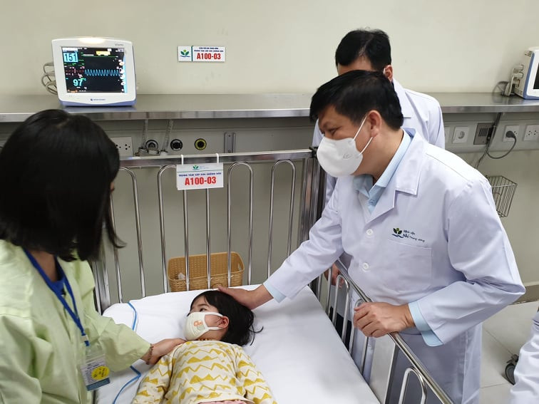 Động viên bệnh nhi và gia đình. (Ảnh: PV/Vietnam+)