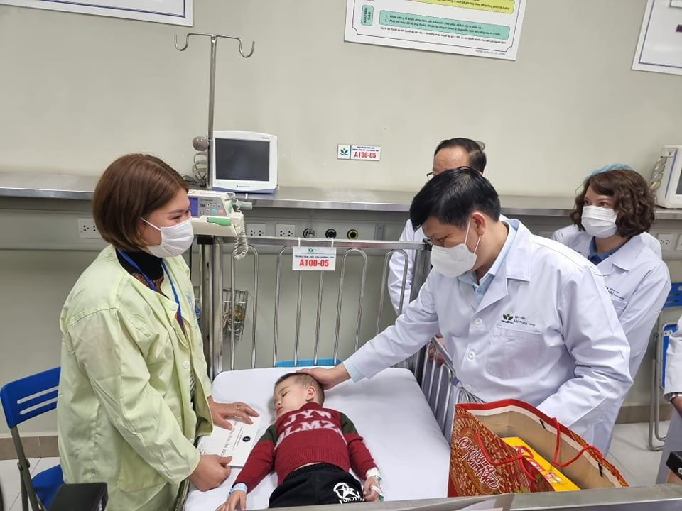 Bộ trưởng Bộ Y tế thăm hỏi sức khoẻ bệnh nhi. (Ảnh: PV/Vietnam+)