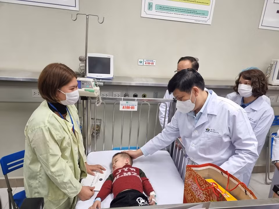 Bộ trưởng Bộ Y tế thăm hỏi sức khoẻ bệnh nhi. (Ảnh: PV/Vietnam+)