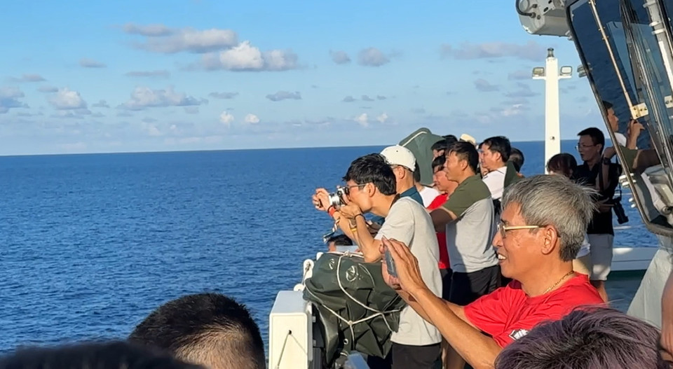 Các thành viên của Đoàn công tác số 21 năm 2024 hào hứng chụp ảnh cá voi "trình diễn" trên biển Đông. (Ảnh: Thùy Giang/Vietnam+)