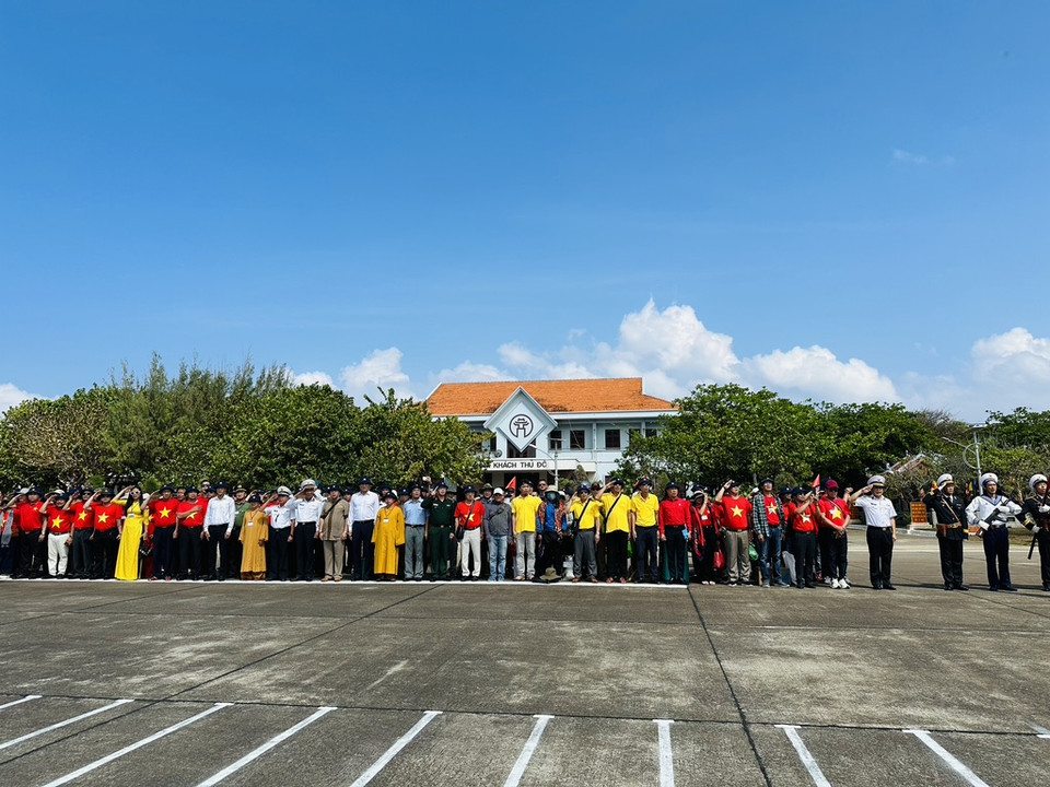 Bà con Kiều bào và các đại biểu làm lễ chào cờ. (Ảnh: T.G/Vietnam+)