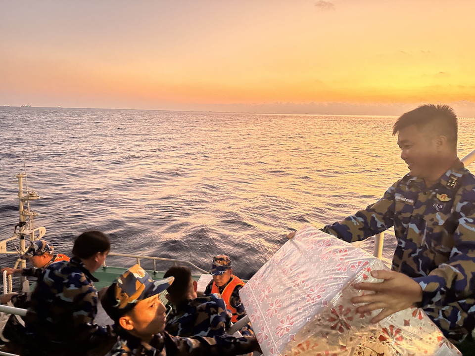 Các thành viên trên tàu vận chuyển hàng hoá là quà tặng cho những chuyến ca nô đầu tiên đi vào đảo. (Ảnh: Thùy Giang/Vietnam+)