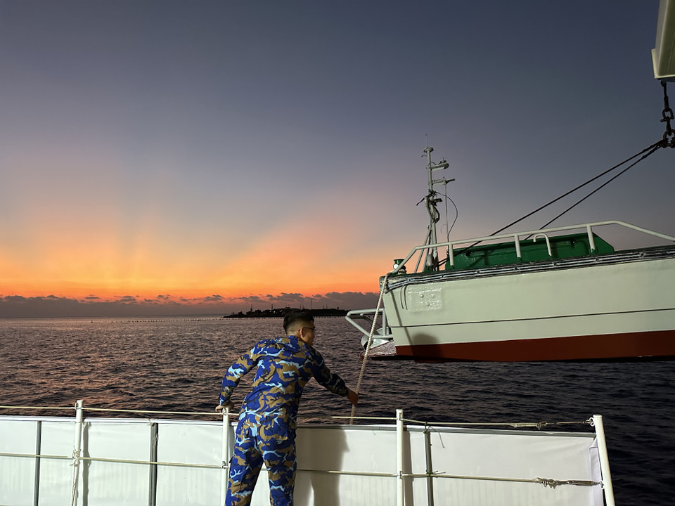 Cán bộ, thủy thủ Tàu 571 tiến hành hạ xuồng để đưa đoàn công tác vào Đảo Sinh Tồn Đông. (Ảnh: Thùy Giang/Vietnam+)