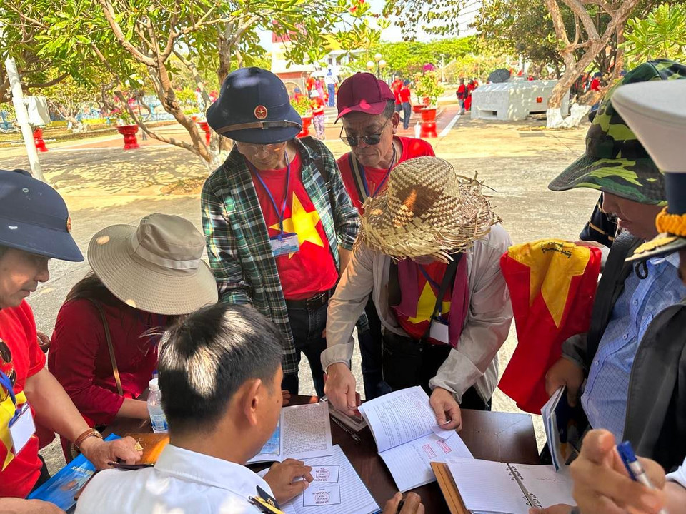 Nhiều Việt kiều hào hứng đóng dấu lên những vật dụng như sổ, giấy tờ. (Ảnh: T.G/Vietnam+)