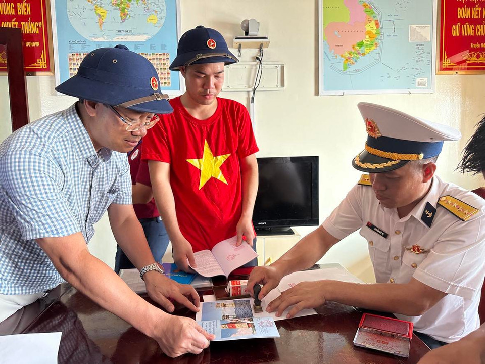 Cán bộ tại Nhà giàn DK1 đóng dấu cho đoàn công tác và kiều bào. (Ảnh: T.G/Vietnam+)