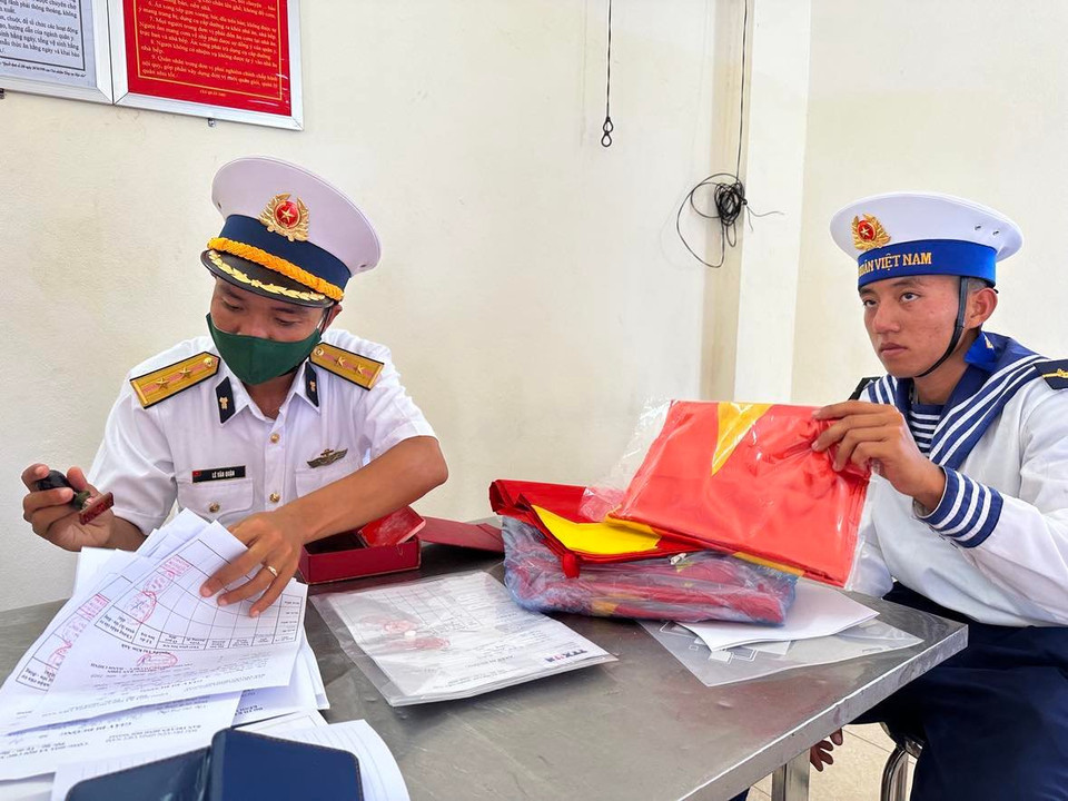 Hàng trăm tờ giấy công tác, đến sổ và lá cờ được người dân và đoàn công tác đưa ra đóng dấu. (Ảnh: T.G/Vietnam+)