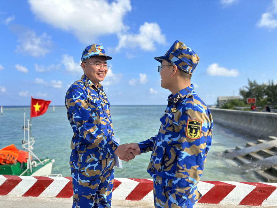 Phó Thuyền trưởng Tàu 571 Trần Ngọc Sáng chia sẻ kinh nghiệm với Phó Thuyền trưởng Nguyên Phi Hoàng của tàu Trường Sa 20 đang làm nhiệm vụ trên biển khu vực đảo Trường Sa. (Ảnh: Thùy Giang/Vietnam+)