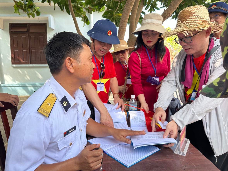 Cán bộ giải thích cho người dân về các thủ tục đóng dấu. (Ảnh: T.G/Vietnam+)