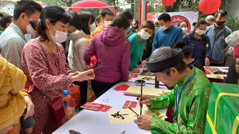 Viết thư pháp cho các bệnh nhi trong chương trình. (Ảnh: T.G/Vietnam+)