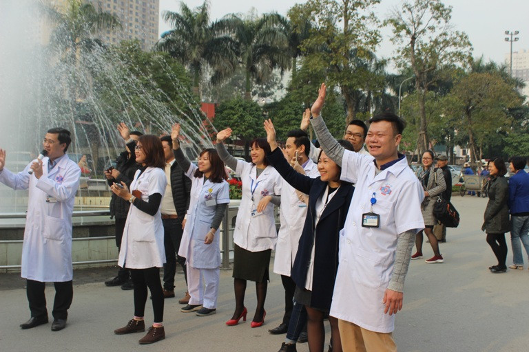 Các bác sỹ vẫy chào tạm biệt bệnh nhân. (Ảnh: PV/Vietnam+)