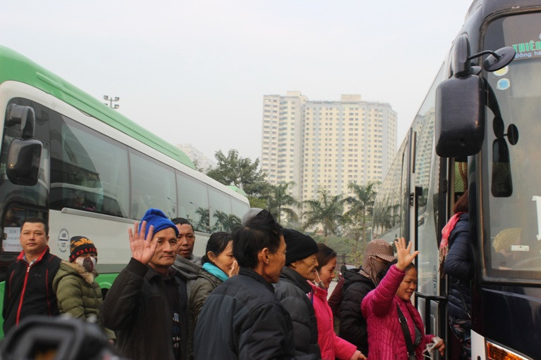 Những bệnh nhân ung thư vui vẻ lên xe về quê ăn Tết. (Ảnh: PV/Vietnam+)