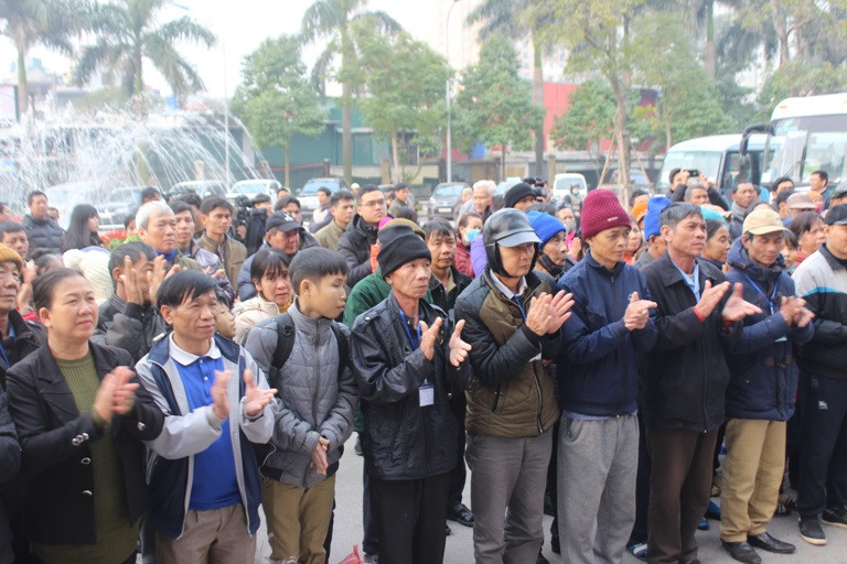 Các bệnh nhân và người nhà bệnh nhân trước giờ lên xe. (Ảnh: PV/Vietnam+)