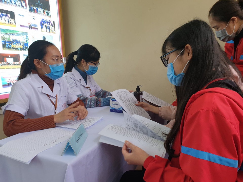 Các tình nguyện viên đọc kỹ các nội dung trong bản đăng ký. (Ảnh: T.G/Vietnam+)