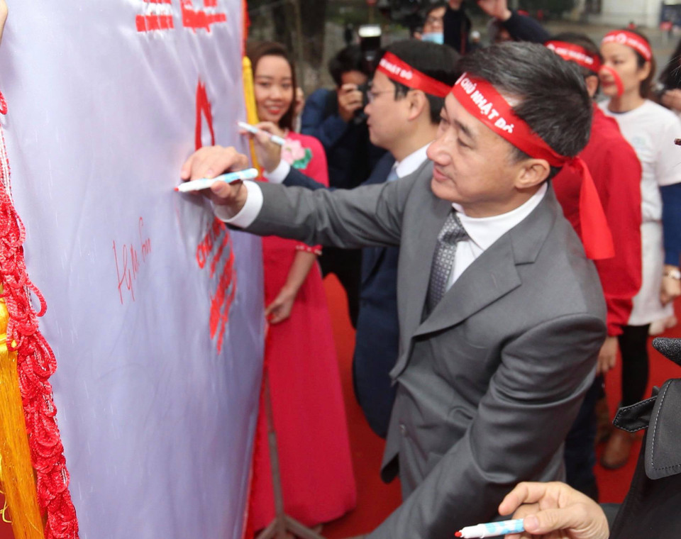 Tại chương trình, các đại biểu, hoa hậu, người đẹp cùng thực hiện nghi lễ ký tên vào lá cờ Chủ nhật Đỏ. (Ảnh: PV/Vietnam+)