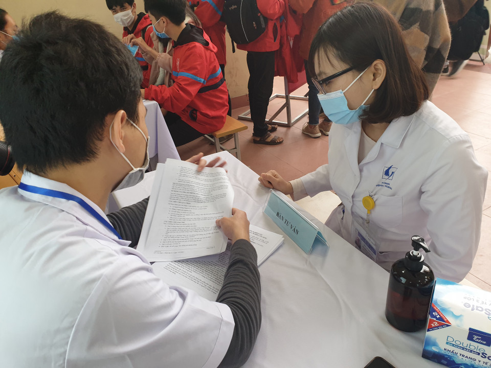 Nhân viên y tế hướng dẫn, giải thích cho các tình nguyện viên. (Ảnh: T.G/Vietnam+)