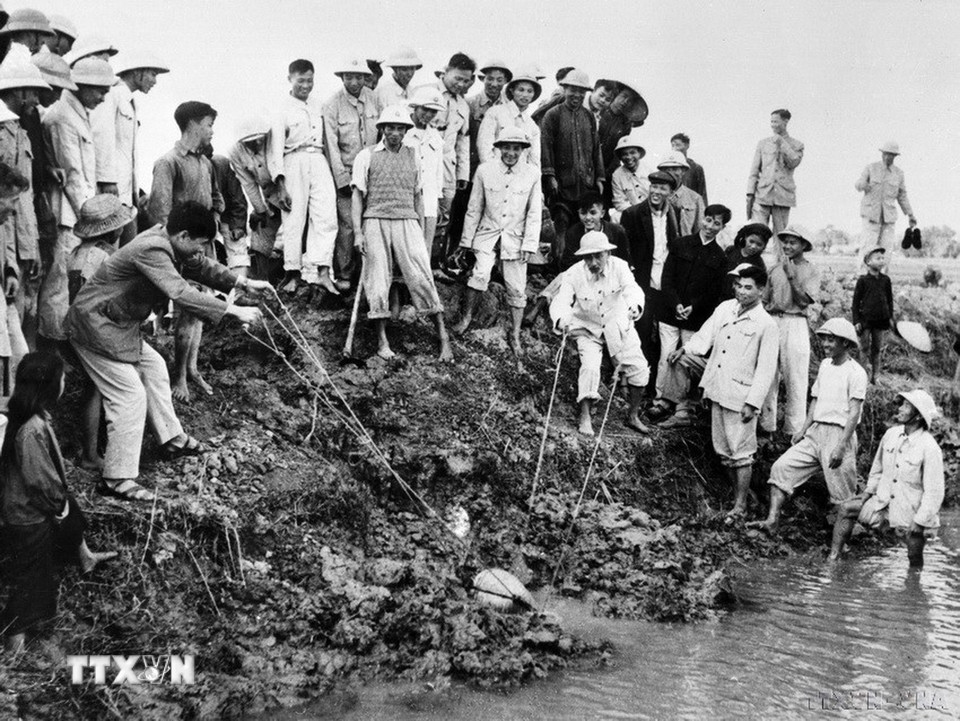 Chủ tịch Hồ Chí Minh tát nước chống hạn với bà con nông dân xã Đại Thanh, tỉnh Hà Đông (nay là Hà Nội) ngày 12/1/1958. (Ảnh: Đinh Đăng Định/TTXVN)