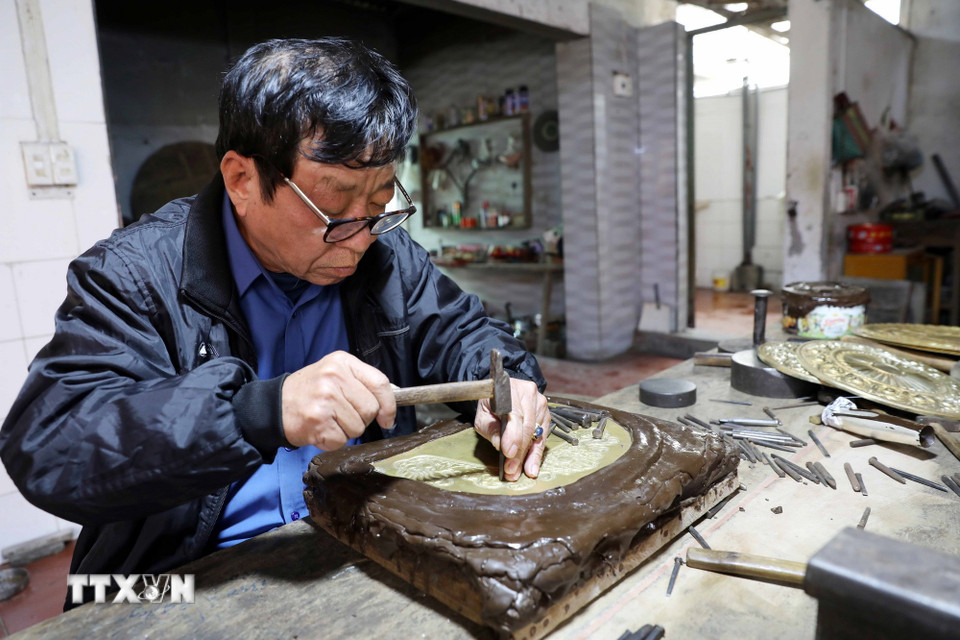 Nghệ nhân Đinh Quang Thắng (66 tuổi, thôn Nam Hòa, xã Hồng Thái) khắc chạm thủ công bằng kỹ thuật tinh xảo. (Ảnh: Thế Duyệt/TTXVN)