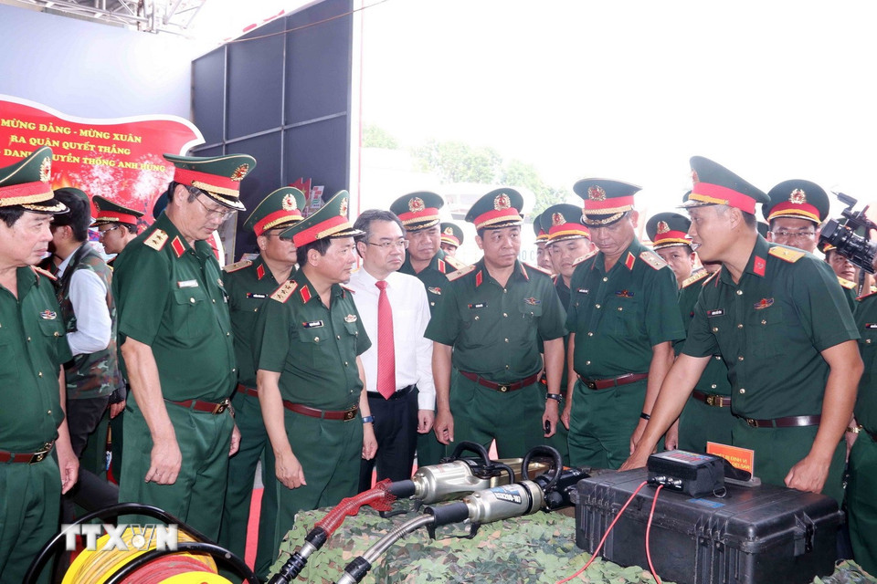 Thượng tướng Trịnh Văn Quyết, Bí thư Trung ương Đảng, Chủ nhiệm Tổng cục Chính trị QĐND Việt Nam và ông Nguyễn Thanh Nghị, Phó Bí thư Thường trực Thành ủy Thành phố Hồ Chí Minh tham quan gian hàng giới thiệu mô hình học cụ, huấn luyện. (Ảnh: Xuân Khu/TTXVN)