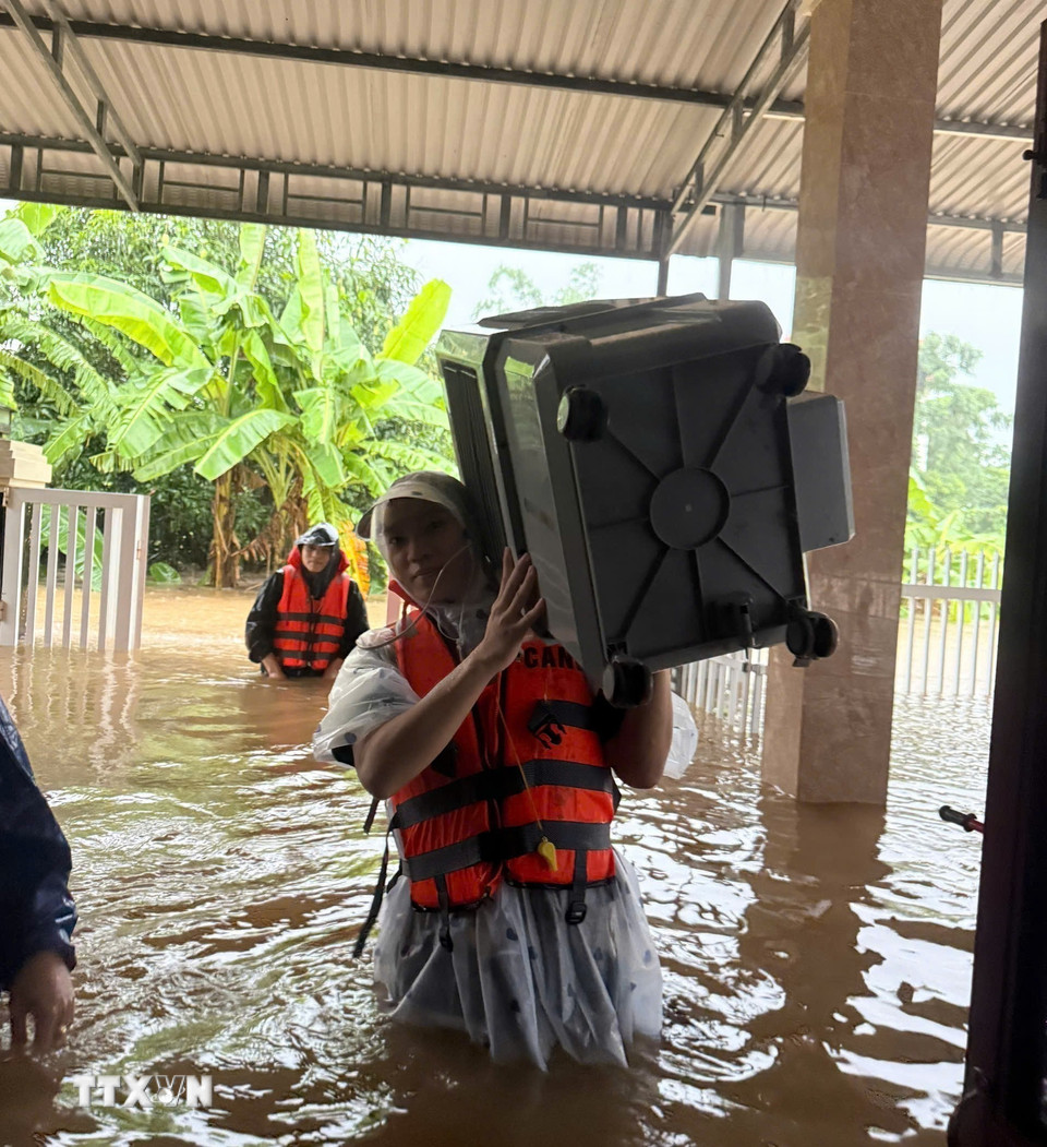 Di dời tài sản của người dân đến nơi an toàn. (Ảnh: TTXVN phát)