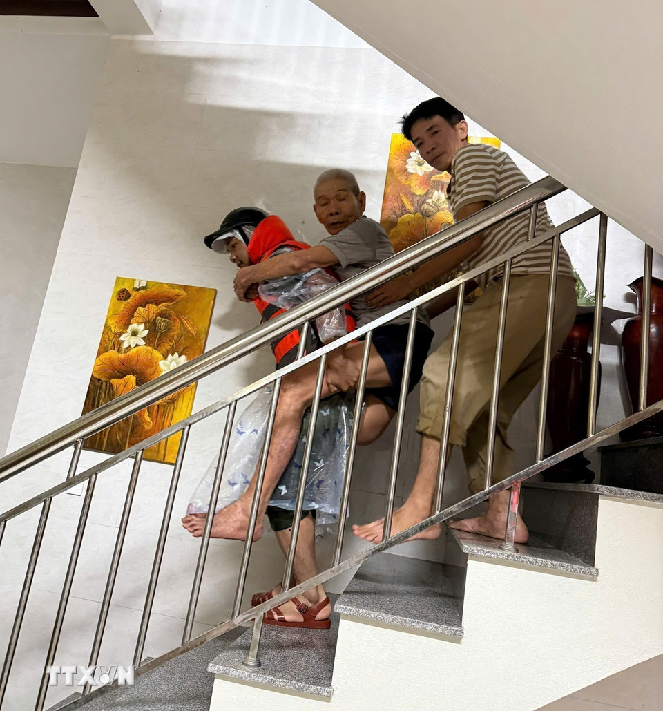 Sơ tán người dân ở vùng ngập lụt thị trấn Lao Bảo đến nơi an toàn. (Ảnh: TTXVN phát)