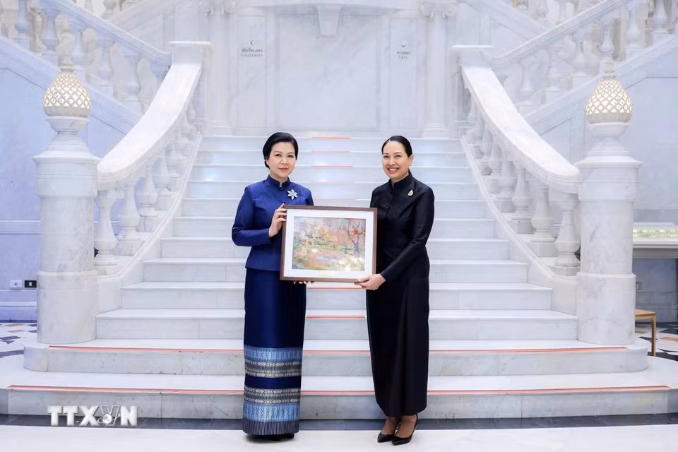 Phu nhân Ngô Phương Ly tặng một bức tranh phong cảnh Việt Nam cho Bảo tàng Dệt may Hoàng Thái hậu Sirikit. (Ảnh: TTXVN phát)