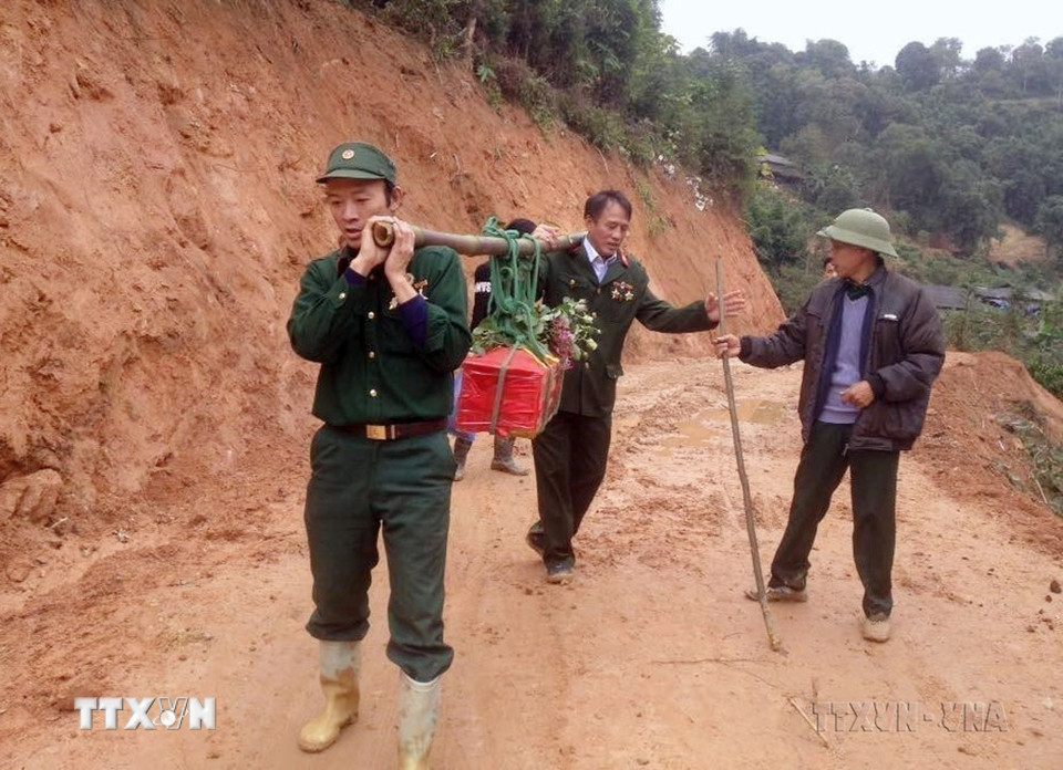 Cựu chiến binh Nguyễn Văn Kim và đồng đội đưa hài cốt liệt sỹ Đình Văn Chung (hy sinh trên cao điểm 900, mặt trận Vị Xuyên, Hà Giang) về nghĩa trang liệt sĩ xã Thanh Thủy. (Ảnh: TTXVN phát)