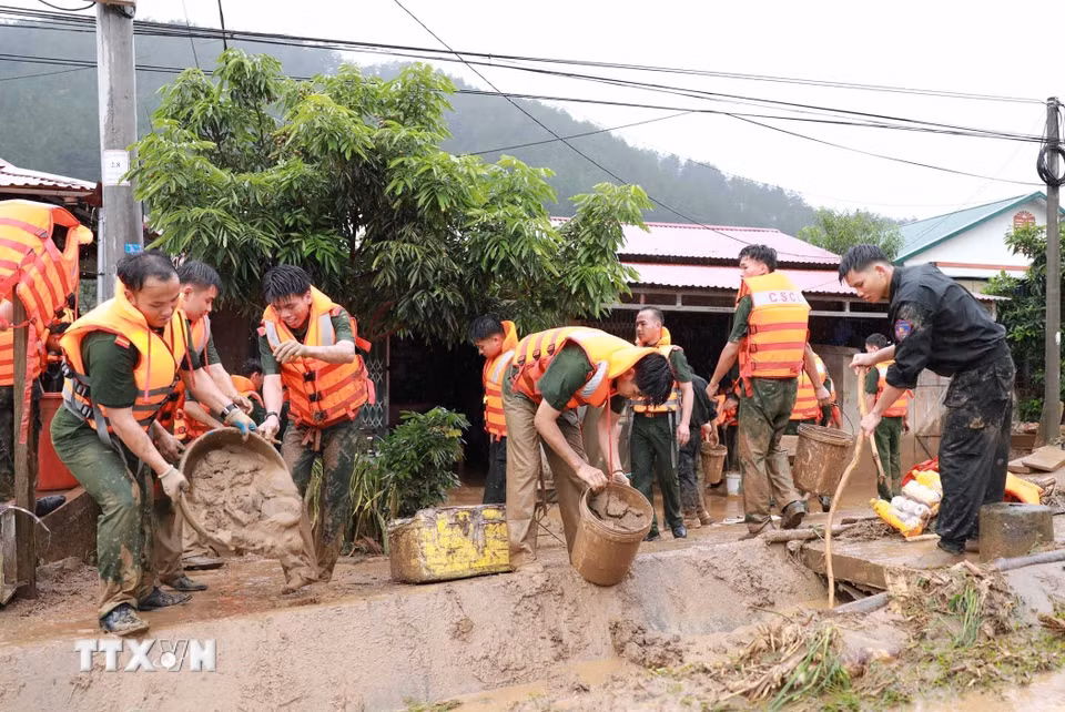 Lực lượng Công an tỉnh Lai Châu hỗ trợ người dân khắc phục. (Ảnh: Quý Trung/TTXVN)