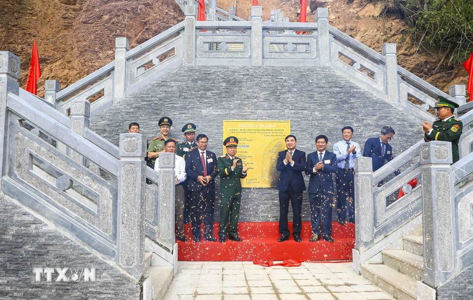 Đại biểu thực hiện nghi thức gắn biển công trình Cột cờ A Pa Chải. (Ảnh: Xuân Tư/TTXVN)