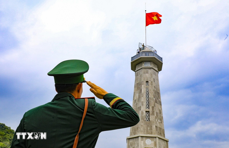 Chiến sỹ thực hiện nghi thức chào cờ tại Cột cờ A Pa Chải. (Ảnh: Xuân Tư/TTXVN)