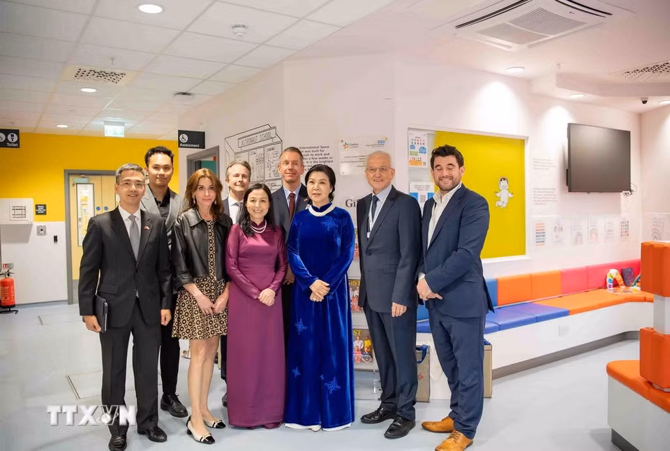 Phu nhân Ngô Phương Ly chụp ảnh lưu niệm cùng các bác sỹ Bệnh viện Nhi Evelina, London. (Ảnh: TTXVN phát)