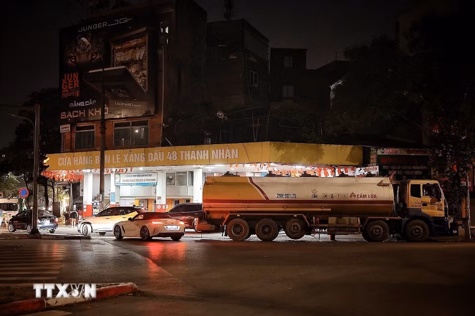 Tối 31/5, tại cửa hàng bán lẻ xăng dầu 48 Thanh Nhàn, nhiều phương tiện vẫn tranh thủ vào đổ xăng RON95 trước thời điểm chuyển đổi sang xăng E10. Theo chia sẻ của quản lý cửa hàng, đúng 0h ngày 1/6/2026, đơn vị sẽ bắt đầu chuyển sang bán xăng E10; xe bồn đã túc trực chờ nhập nhiên liệu mới sau khi bán nốt lượng xăng còn lại trong ngày. (Ảnh: Phạm Tuấn Anh/TTXVN)