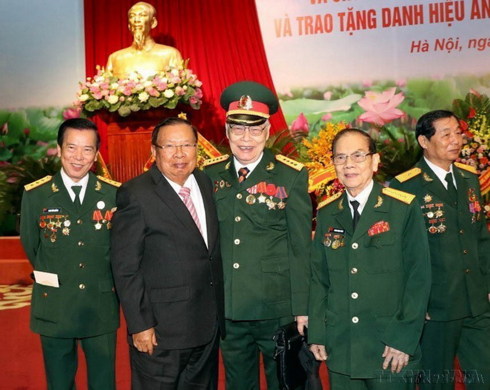Tổng Bí thư, Chủ tịch nước CHDCND Lào Bounnhang Vorachith cùng các cựu chiến binh Việt Nam tại Lễ kỷ niệm 70 năm Ngày truyền thống Quân tình nguyện và Chuyên gia Việt Nam tại Lào (2019). (Ảnh: Trọng Đức/TTXVN)