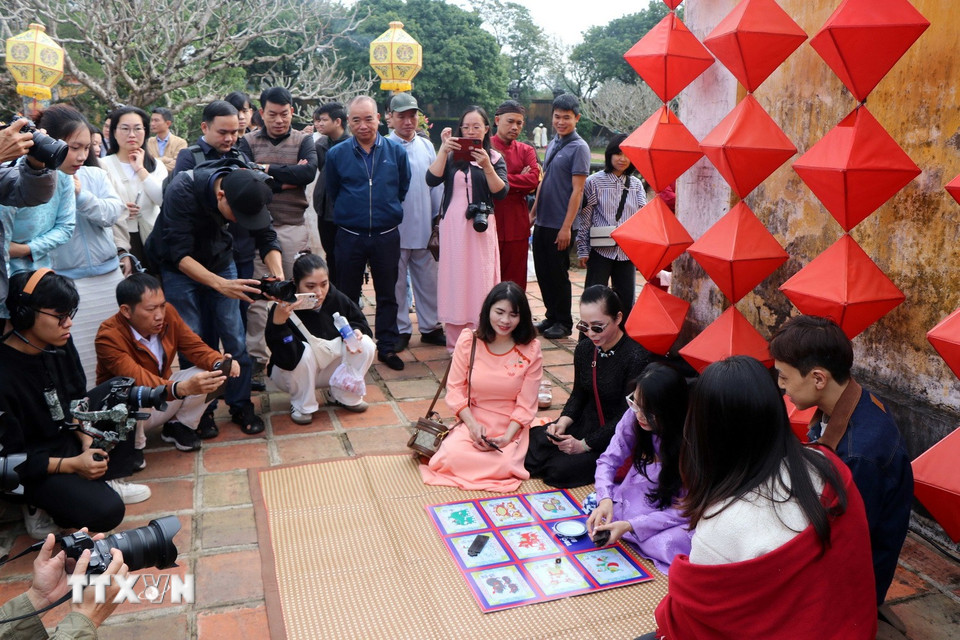 Du khách thích thú tham gia trò chơi truyền thống ngày Tết ở Cung Trường Sanh trong Đại Nội Huế. (Ảnh: Đỗ Trưởng/TTXVN)