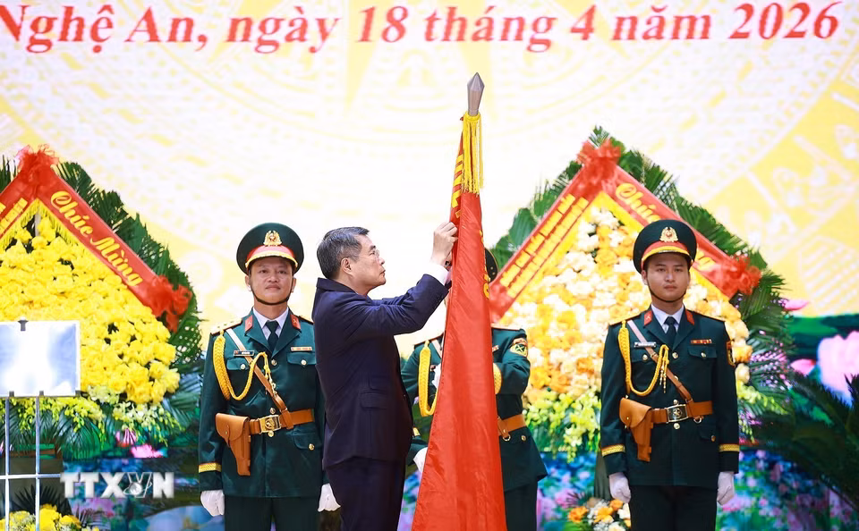 Thủ tướng Lê Minh Hưng gắn danh hiệu Anh hùng Lực lượng vũ trang nhân dân cho lên Cờ truyền thống của Quân khu 4. (Ảnh: Dương Giang/TTXVN)