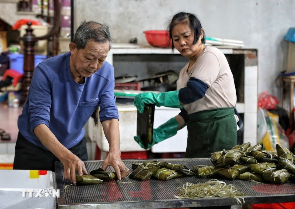 Thao tác ép bánh cho ráo nước sau khi luộc. (Ảnh: Việt Hùng/TTXVN)