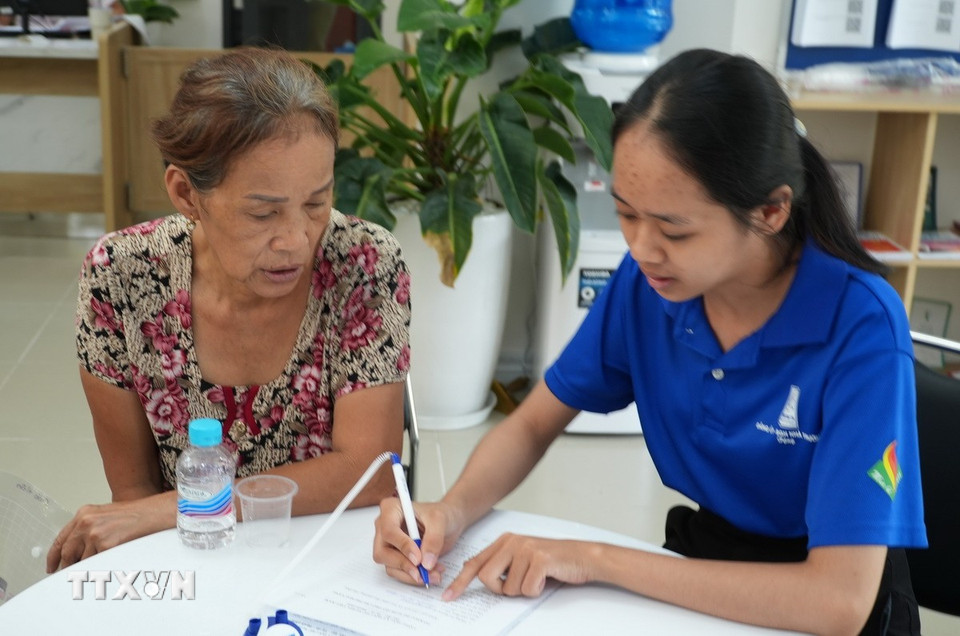 Người cao tuổi được hỗ trợ khai và nộp hồ sơ dịch vụ công trực tuyến. (Ảnh: Hữu Duyên/TTXVN)