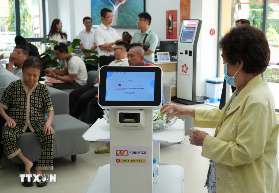 Người dân trải nghiệm các robot phục vụ. (Ảnh: Hữu Duyên/TTXVN)