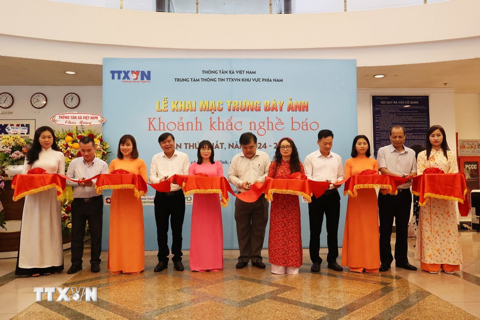 Nghi thức cắt băng khai mạc Trưng bày ảnh Khoảnh khắc nghề báo lần thứ nhất. (Ảnh: Hồng Đạt/TTXVN)