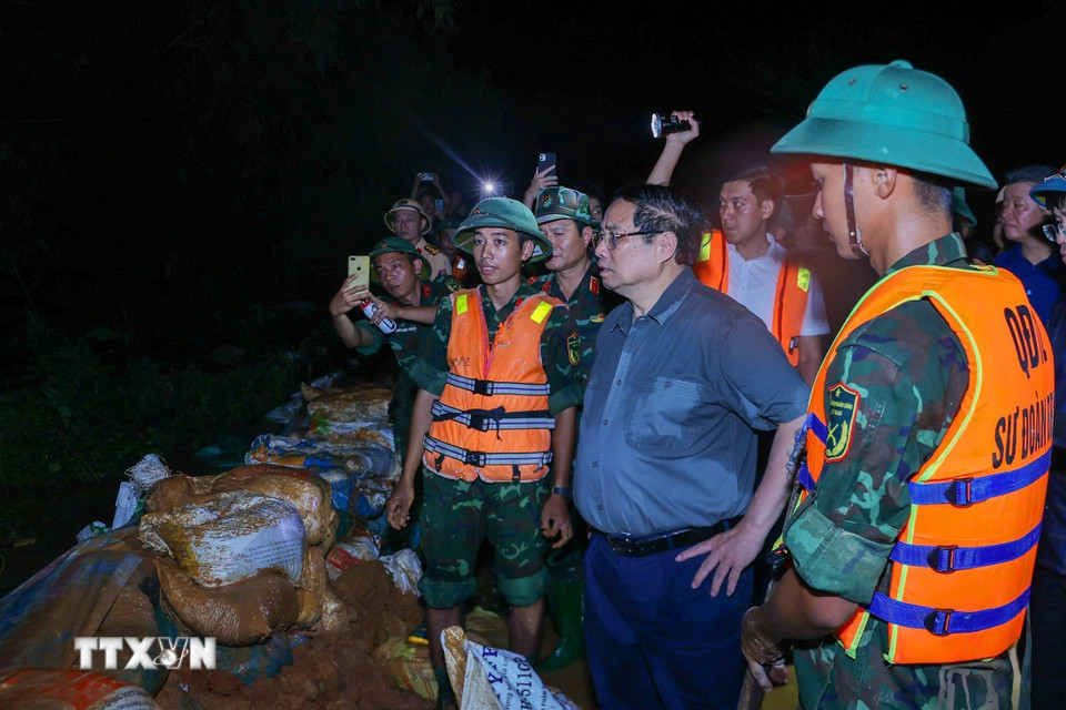 Thủ tướng Phạm Minh Chính chỉ đạo phòng chống lũ, ứng cứu sự cố, bảo đảm an toàn tuyến đê hữu Cầu. (Ảnh: Dương Giang/TTXVN)