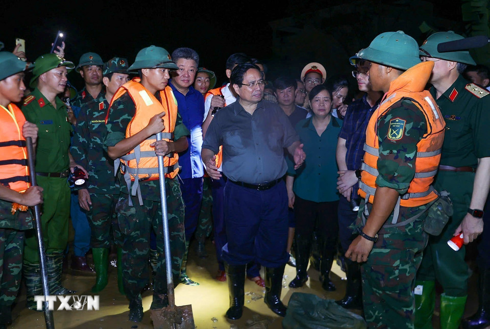 Thủ tướng Phạm Minh Chính chỉ đạo phòng chống lũ, ứng cứu sự cố, bảo đảm an toàn tuyến đê hữu Cầu. (Ảnh: Dương Giang/TTXVN)