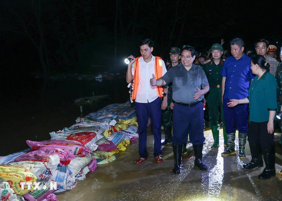 Thủ tướng Phạm Minh Chính chỉ đạo phòng chống lũ, ứng cứu sự cố, bảo đảm an toàn tuyến đê hữu Cầu. (Ảnh: Dương Giang/TTXVN)