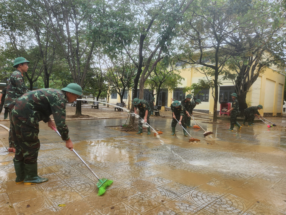Các chiến sỹ Trung đoàn 6, Bộ Chỉ huy Quân sự thành phố Huế hỗ trợ nhân dân dọn dẹp vệ sinh sau mưa lũ. (Ảnh: Mai Trang/TTXVN)