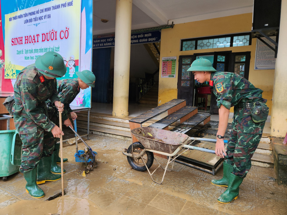 Các chiến sỹ Trung đoàn 6, Bộ Chỉ huy Quân sự thành phố Huế hỗ trợ nhân dân dọn dẹp vệ sinh sau mưa lũ. (Ảnh: Mai Trang/TTXVN)