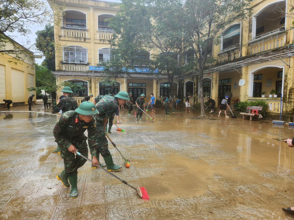Các chiến sỹ Trung đoàn 6, Bộ Chỉ huy Quân sự thành phố Huế hỗ trợ nhân dân dọn dẹp vệ sinh sau mưa lũ. (Ảnh: Mai Trang/TTXVN)