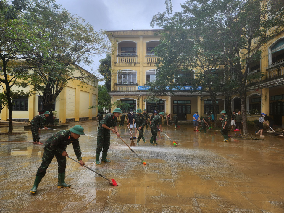 Các chiến sỹ Trung đoàn 6, Bộ Chỉ huy Quân sự thành phố Huế hỗ trợ nhân dân dọn dẹp vệ sinh sau mưa lũ. (Ảnh: Mai Trang/TTXVN)