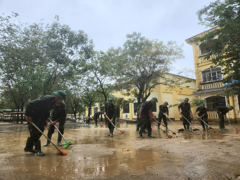 Các chiến sỹ Trung đoàn 6, Bộ Chỉ huy Quân sự thành phố Huế hỗ trợ nhân dân dọn dẹp vệ sinh sau mưa lũ. (Ảnh: Mai Trang/TTXVN)