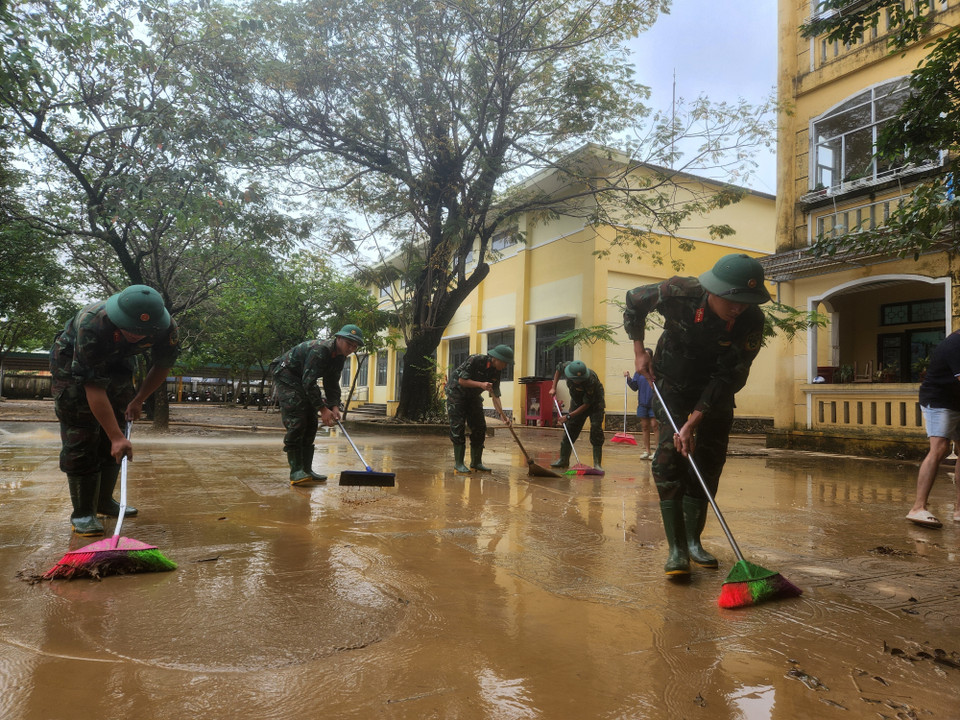Các chiến sỹ Trung đoàn 6, Bộ Chỉ huy Quân sự thành phố Huế hỗ trợ nhân dân dọn dẹp vệ sinh sau mưa lũ. (Ảnh: Mai Trang/TTXVN)