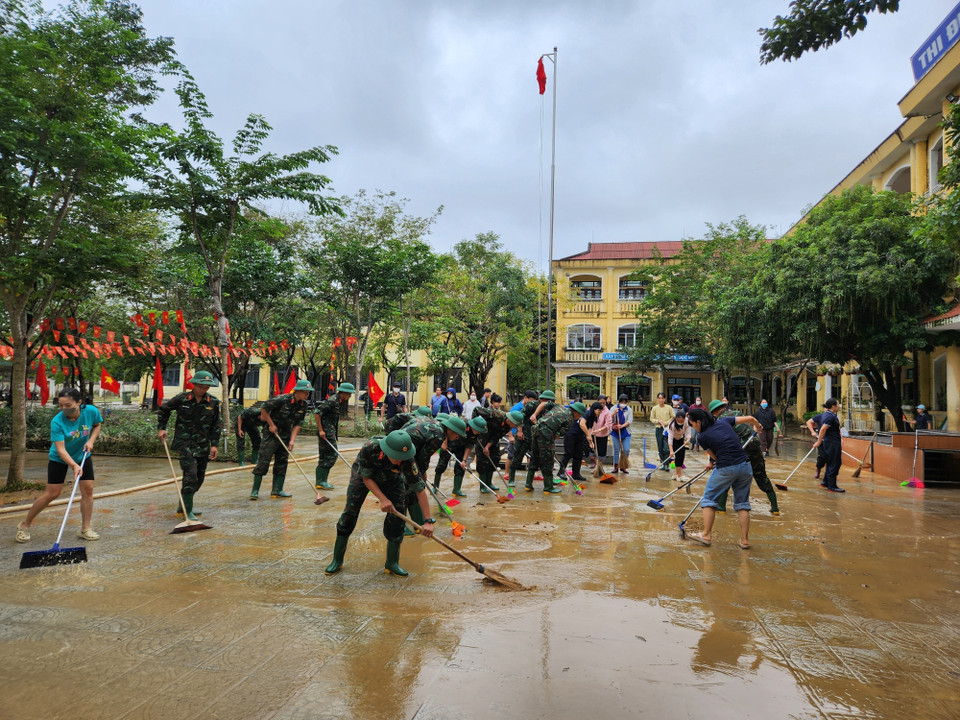 Các chiến sỹ Trung đoàn 6, Bộ Chỉ huy Quân sự thành phố Huế hỗ trợ nhân dân dọn dẹp vệ sinh sau mưa lũ. (Ảnh: Mai Trang/TTXVN)